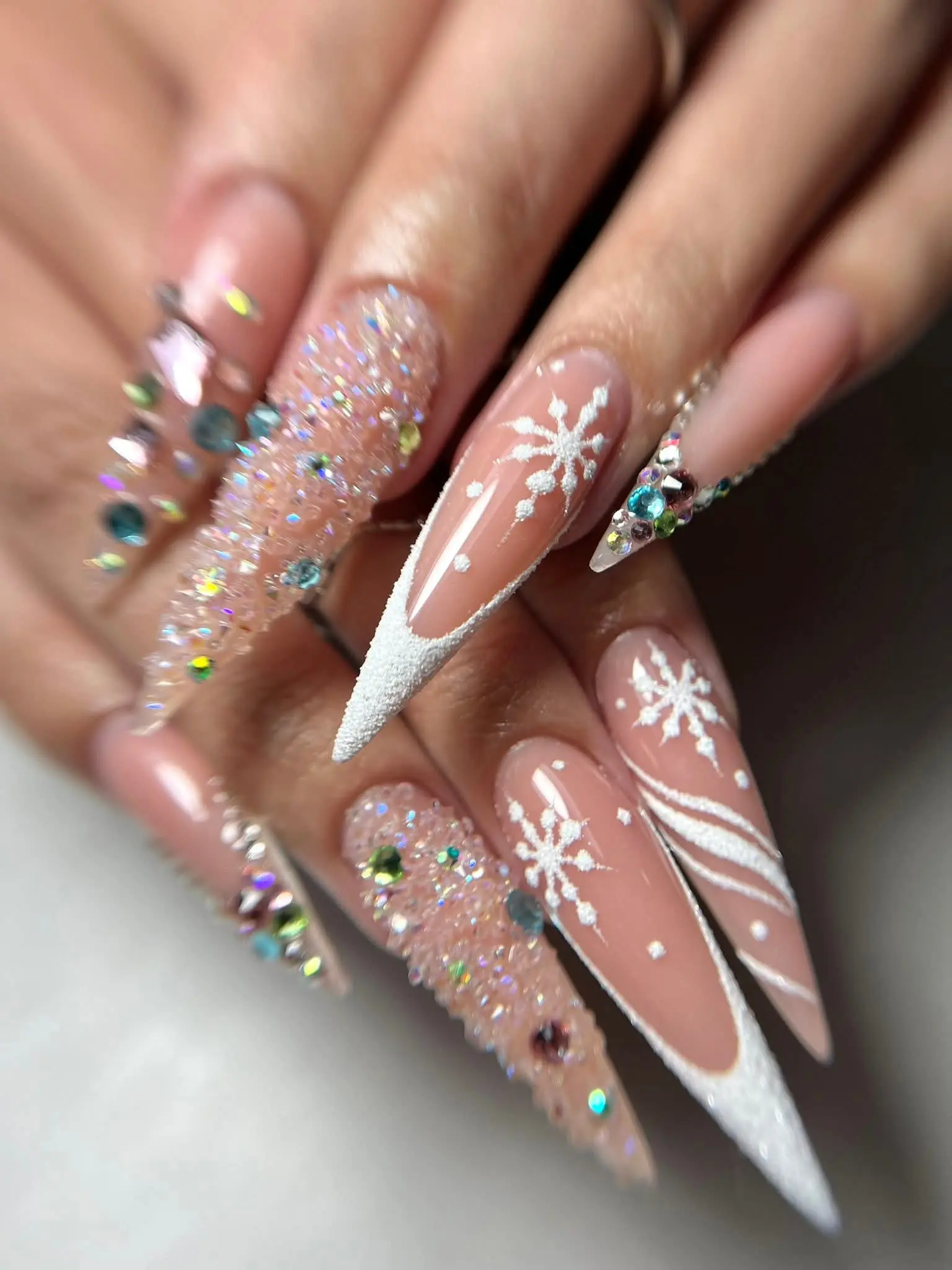 Stiletto-Nägel im Winterdesign mit Schneeflocken, Glitzer und Strass