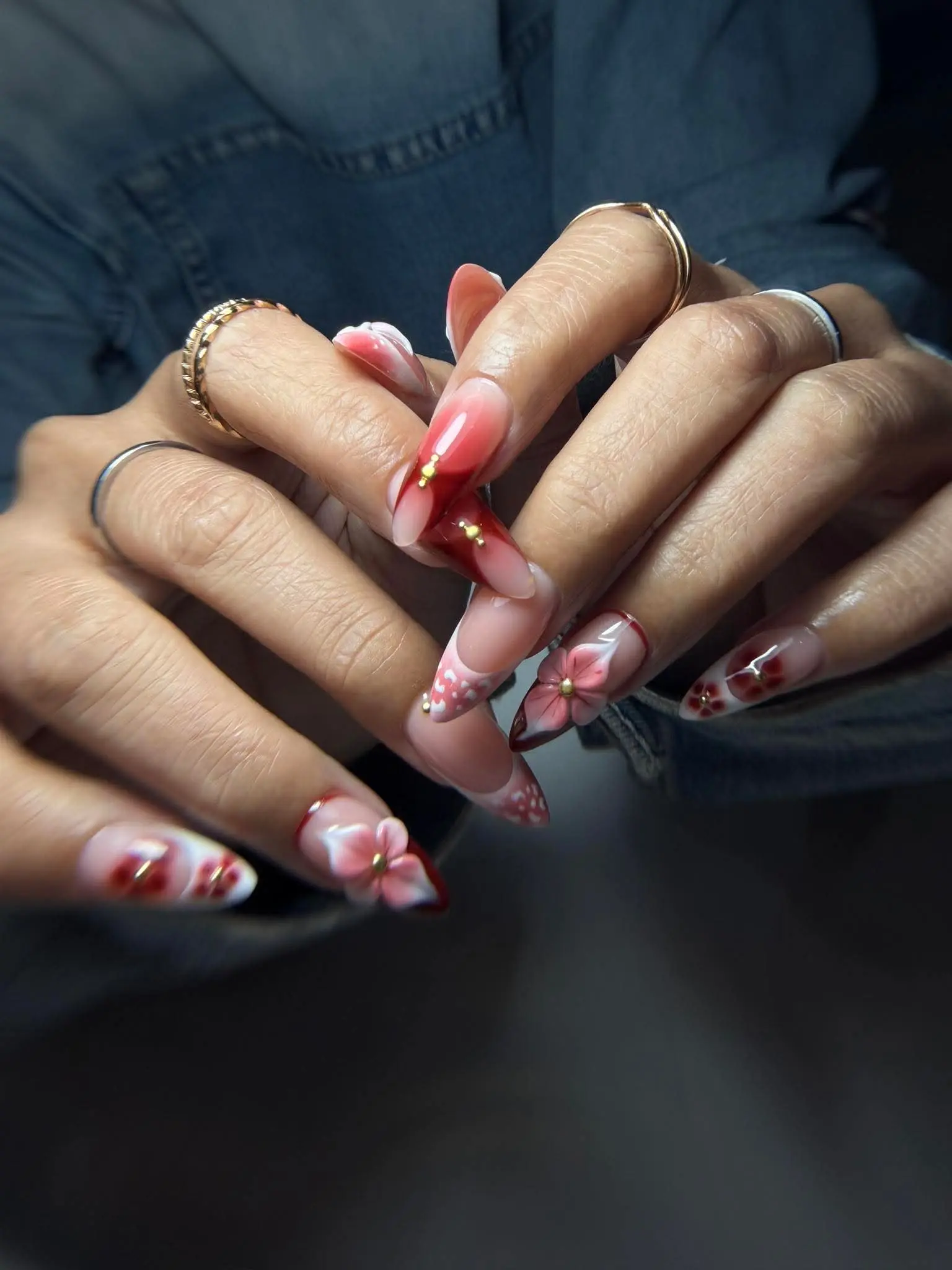 Mandelnägel in Rot und Nude mit 3D-Blüten und goldenen Akzenten